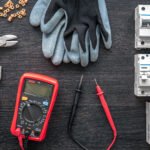 Flat lay composition with electrical tools on wooden background.